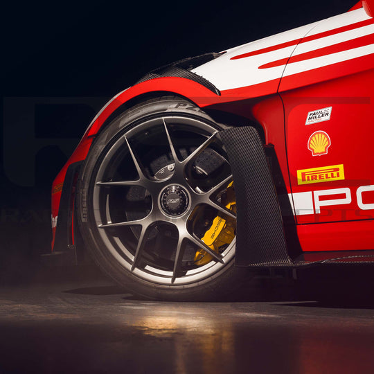 Porsche 992 GT3 RS Carbon Fiber Side Skirts by RSC Close-up of a red sports car wheel with Pirelli and Shell logos on a dark background